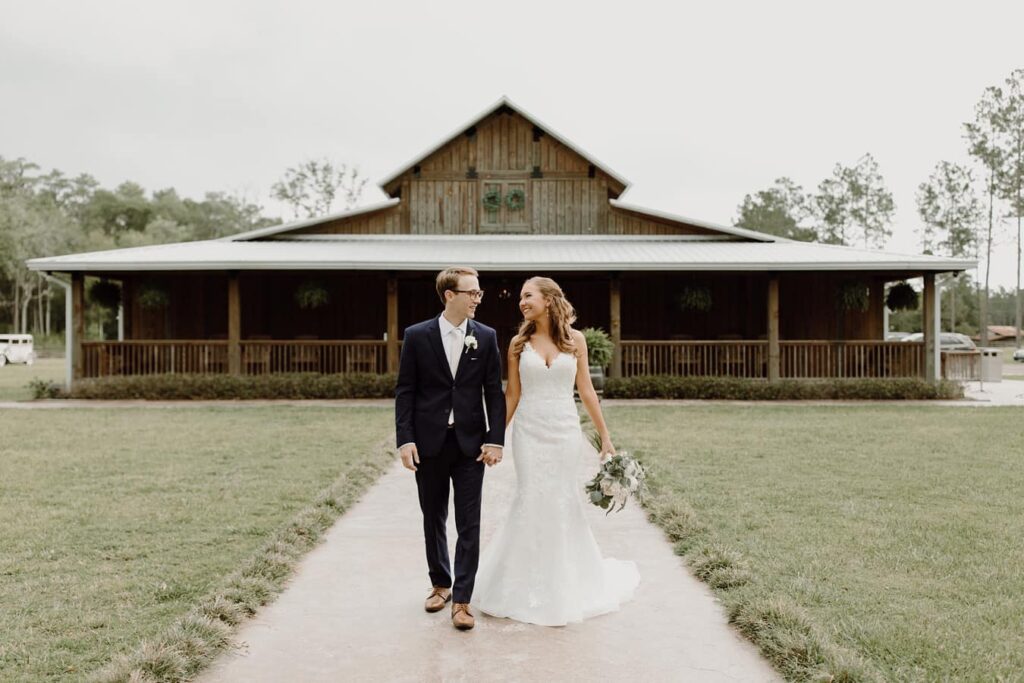 wedding couple walking in front of barn venue
