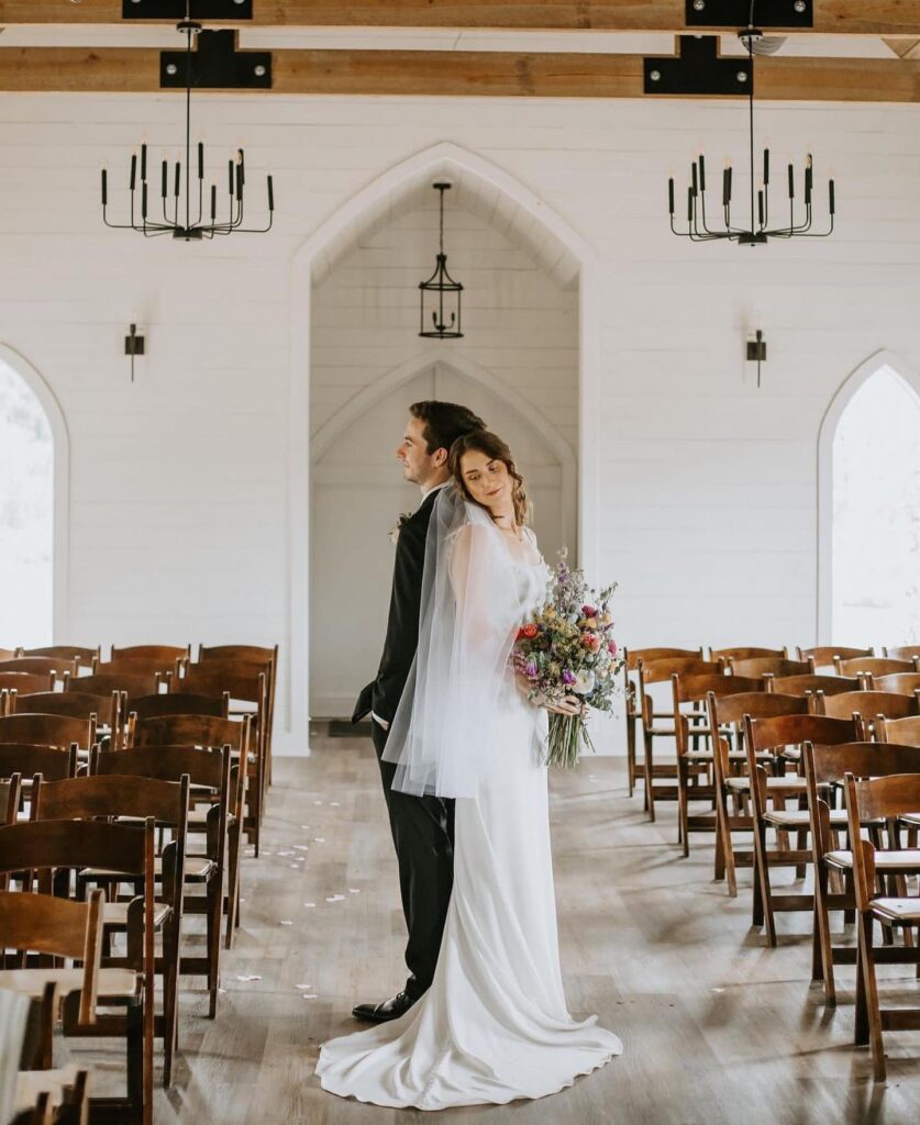 wedding couple posed indoors inside the chapel