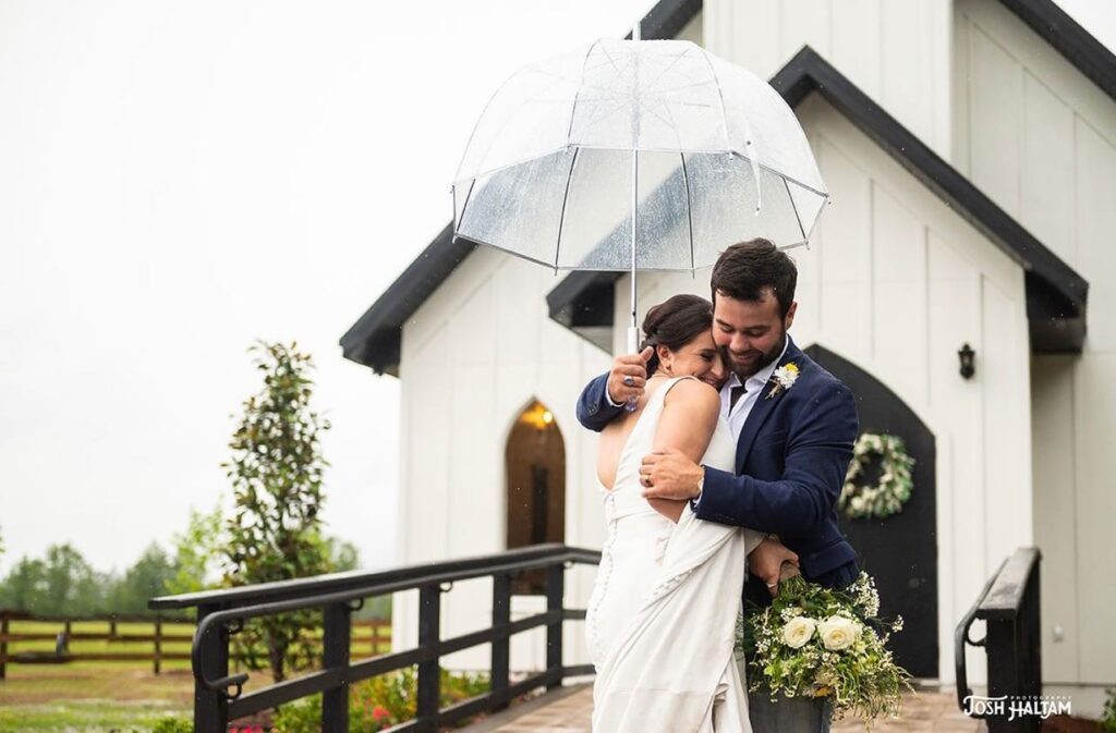 wedding couple under umbrella at the chapel venue