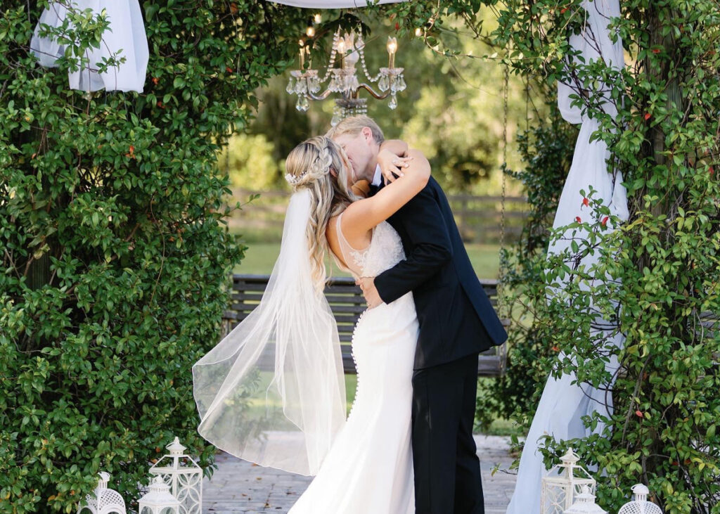 wedding couple kissing in the swing pergola