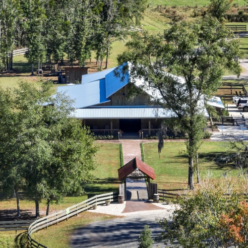 aerial view of barn venue surrounded by green trees and fields