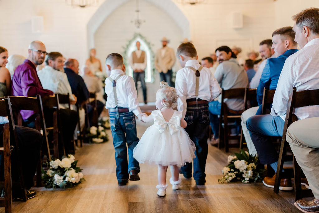 flower girl and ring bearers walking down aisle