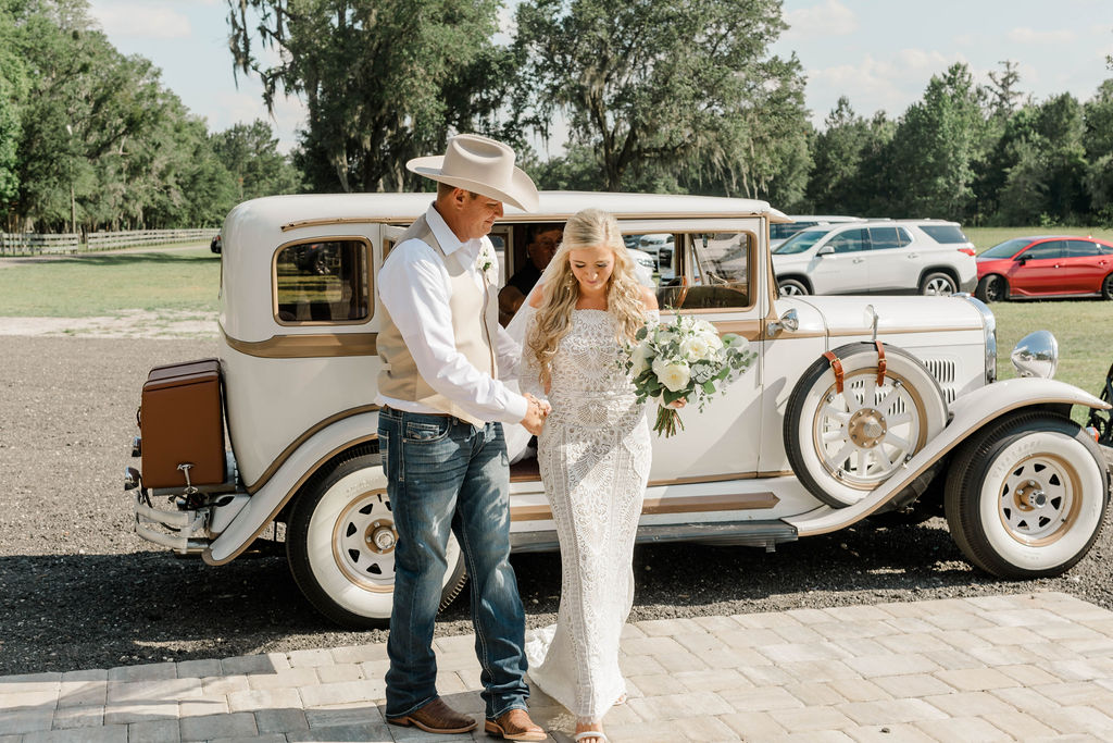 bride and groom about to get in antique getaway car
