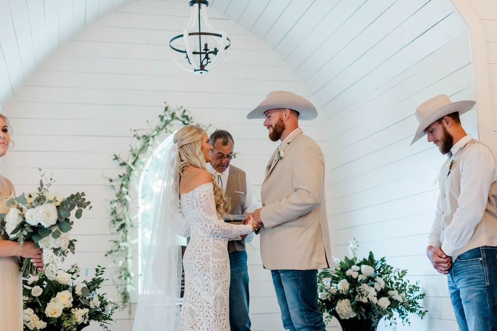 bride and groom smiling at each other during wedding ceremony