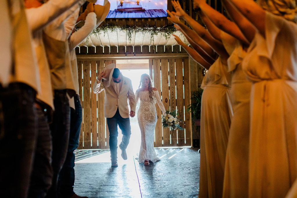 couple holding hands entering wedding reception