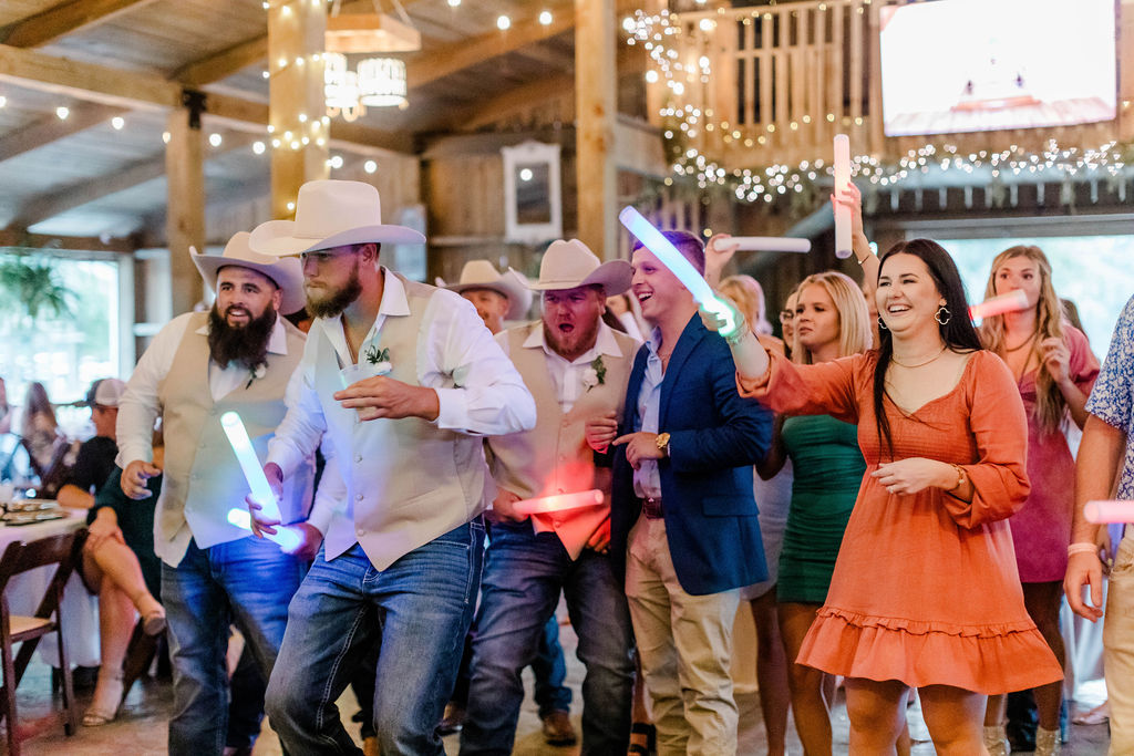 wedding guests dancing and waving glow sticks